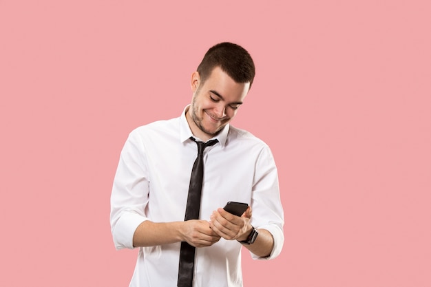 Uomo d'affari bello con il telefono cellulare. giovane uomo d'affari in piedi isolato sul rosa. Bellissimo ritratto maschile a mezzo busto