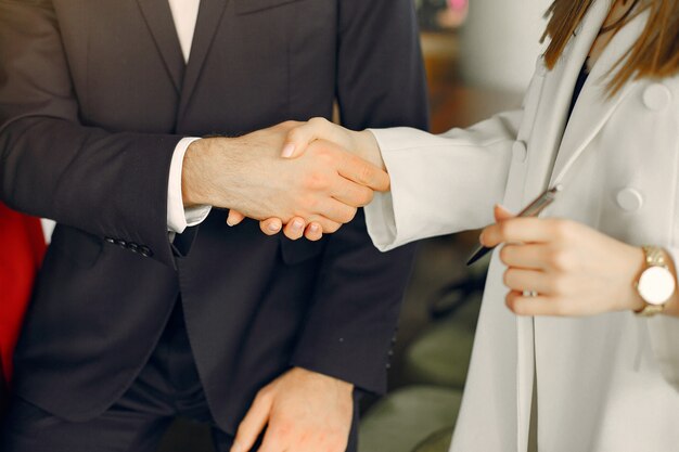 Uomo d'affari bello con le donne che stanno e che lavorano in un caffè