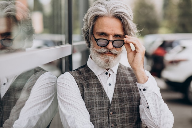 Uomo d'affari bello in piedi fuori e pensare