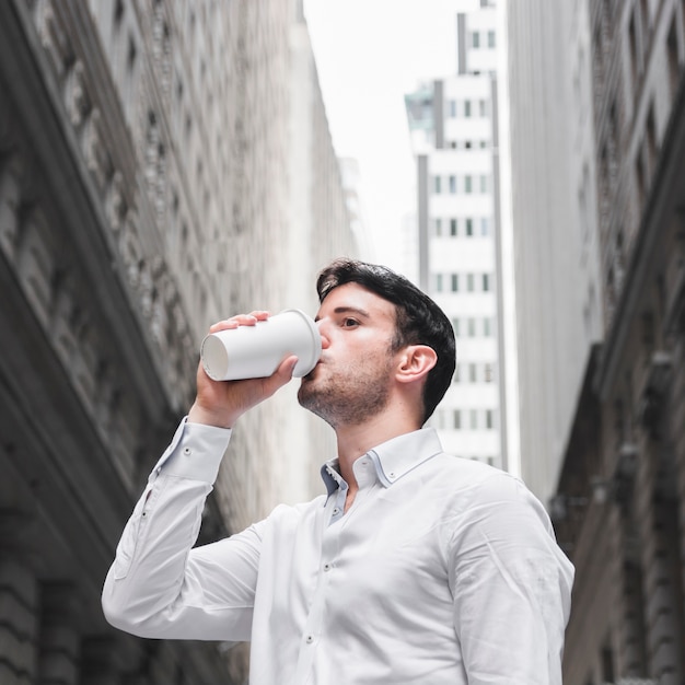 Uomo d&#39;affari che beve sulla strada della città