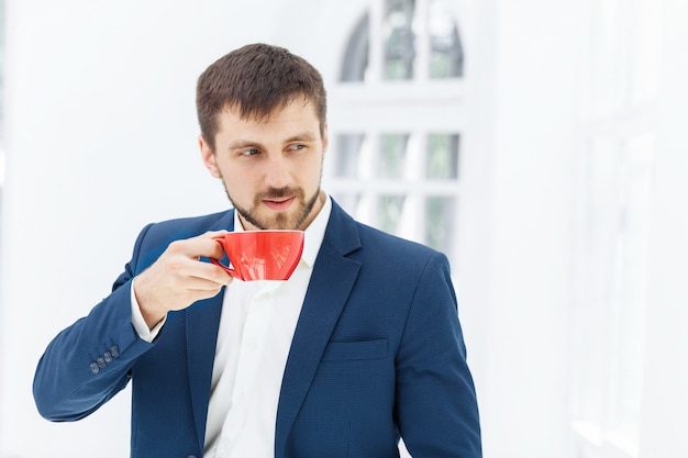 Uomo d'affari che ha pausa caffè, sta tenendo una tazza