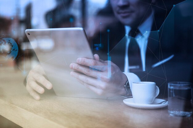 Uomo d'affari che lavora al tablet al bar