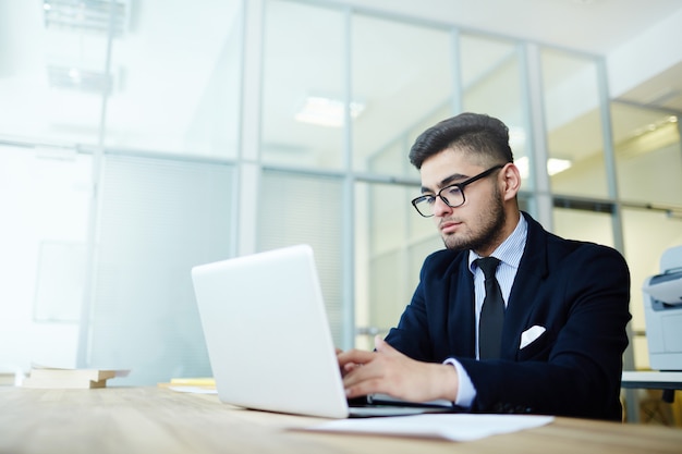 Uomo d'affari che lavora con il computer portatile all'ufficio