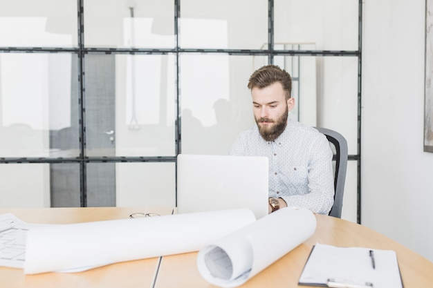 Uomo d&#39;affari che lavora con il computer portatile in ufficio