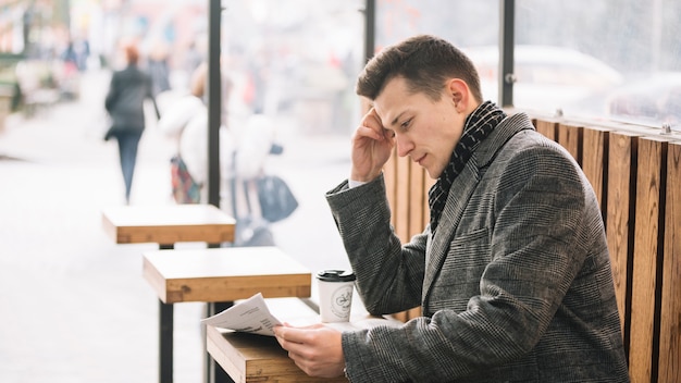 Uomo d&#39;affari che legge su una terrazza