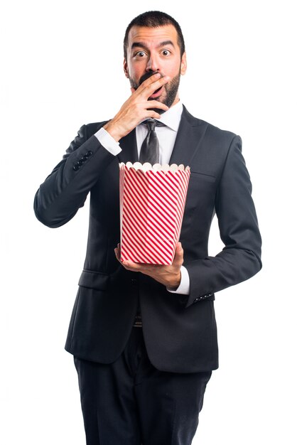 Uomo d&#39;affari che mangia popcorn