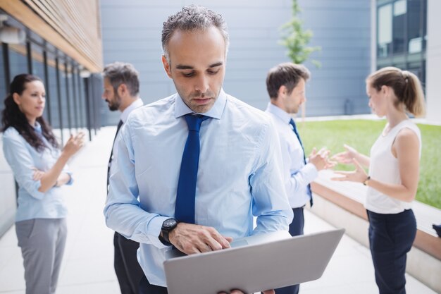 Uomo d'affari che per mezzo del computer portatile