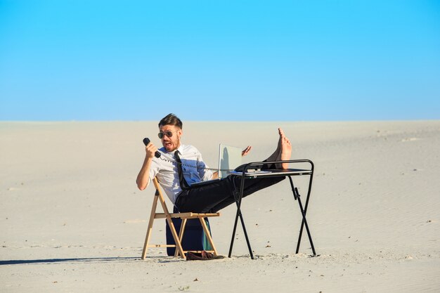 Uomo d'affari che utilizza computer portatile in un deserto