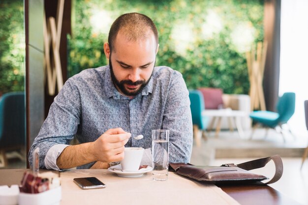 Uomo d&#39;affari con caffè in caf