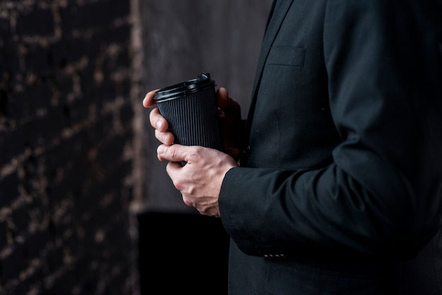 Uomo d'affari con caffè in tazza di carta