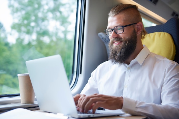 Uomo d'affari con la barba che lavora durante il viaggio