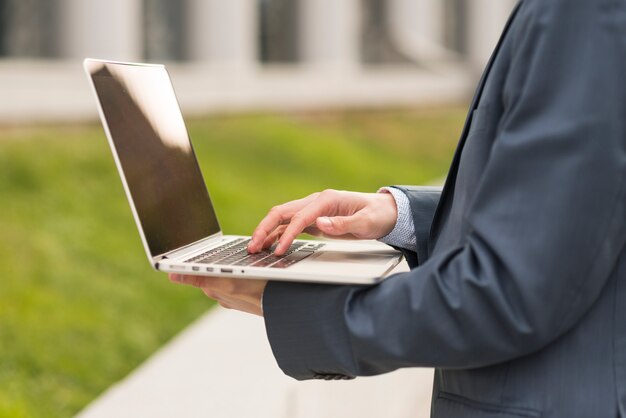 Uomo d&#39;affari con laptop all&#39;aperto