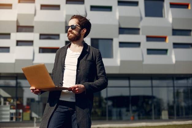 Uomo d&#39;affari elegante che lavora nell&#39;erba