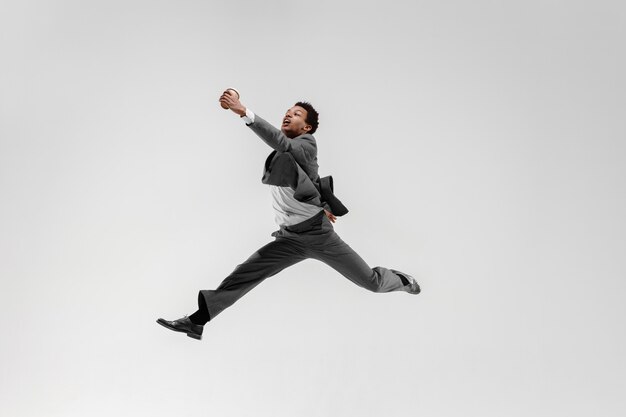 Uomo d'affari felice ballando in movimento isolato su sfondo bianco studio. Flessibilità e grazia negli affari. Concetto di emozioni umane. Ufficio, successo, professionale, felicità, concetti di espressione