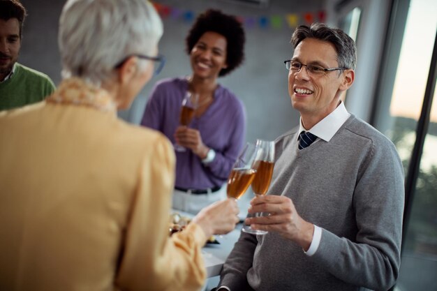 Uomo d'affari felice che brinda con il collega sulla festa dell'ufficio