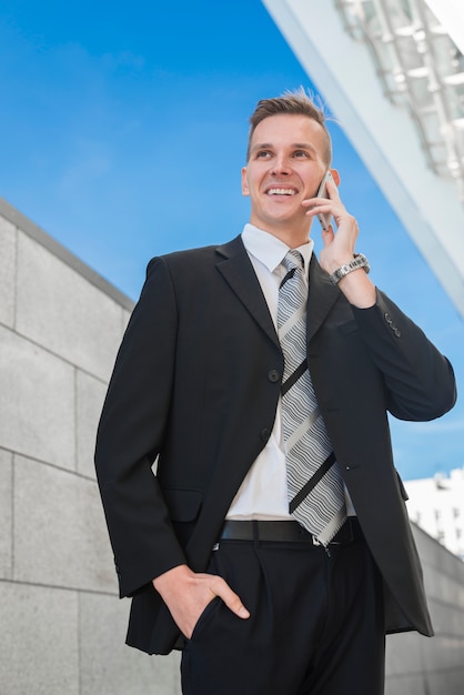 Uomo d&#39;affari felice che fa telefonata