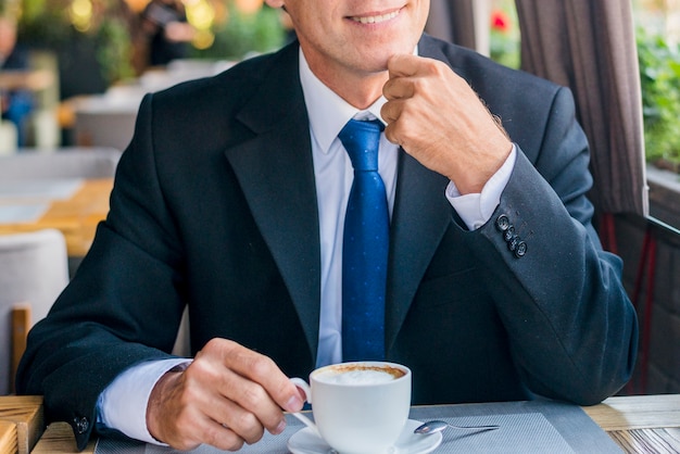 Uomo d&#39;affari felice con la tazza di caffè nel caf�