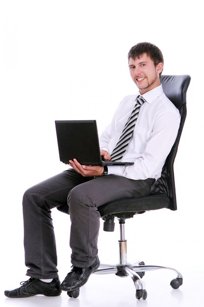 Uomo d'affari felice sulla sedia con il computer portatile