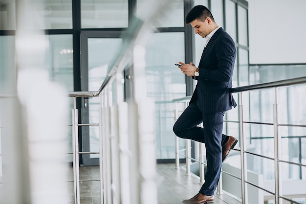 Uomo d'affari giovane parla al telefono in ufficio