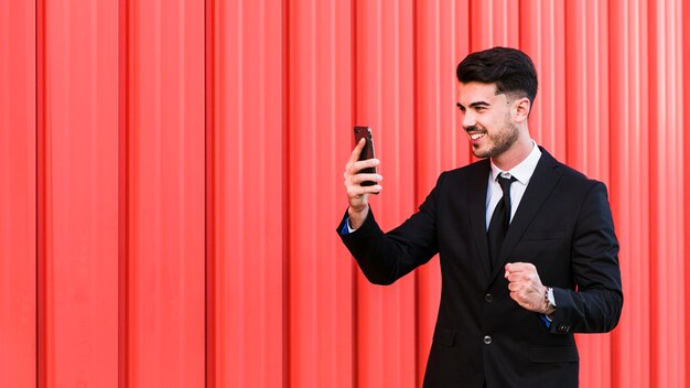 Uomo d&#39;affari guardando il suo telefono cellulare