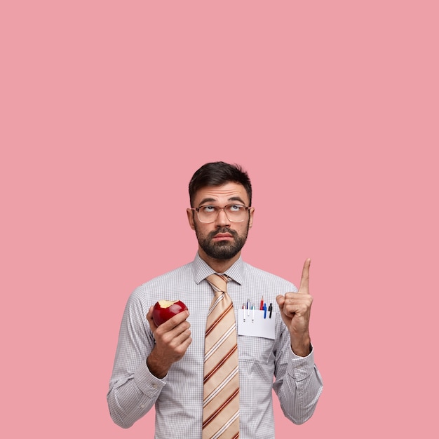 Uomo d'affari in abiti formali tenendo la mela