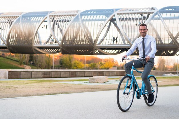 Uomo d'affari in sella a una bicicletta d'epoca nel cityxA