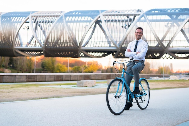 Uomo d'affari in sella a una bicicletta d'epoca nel cityxA