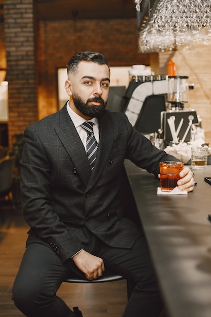 Uomo d'affari in un pub con cocktail