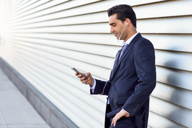 uomo d&#39;affari l&#39;ascolto di musica sul suo cellulare