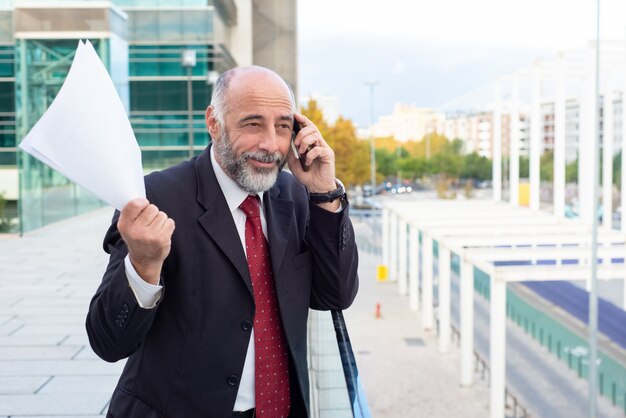 Uomo d'affari maturo positivo felice che discute accordo