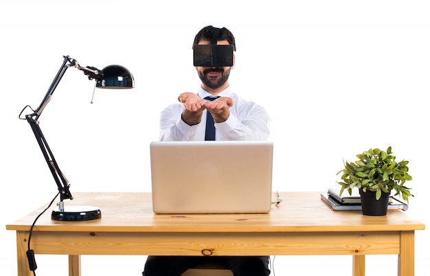 Uomo d&#39;affari nel suo ufficio utilizzando vetri VR in possesso di qualcosa