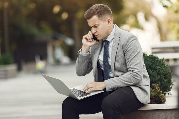 Uomo d'affari. Ragazzo in giacca e cravatta. Il maschio usa un laptop.