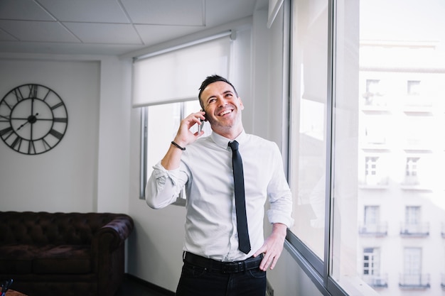 Uomo d&#39;affari sul telefono ridendo