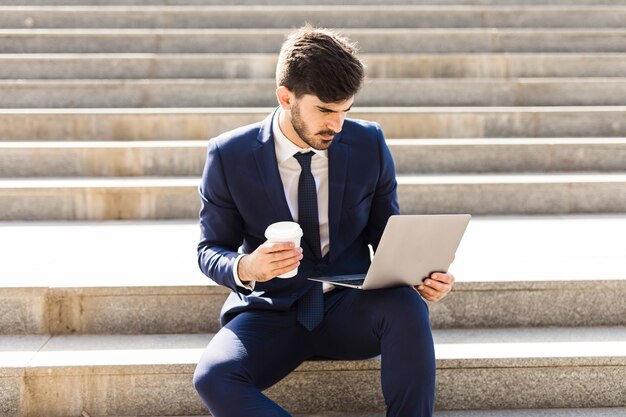 Uomo d&#39;affari usando il suo computer portatile