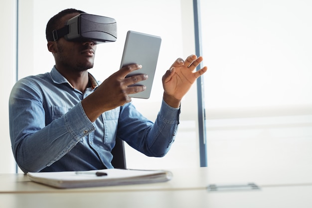 Uomo d'affari utilizzando le cuffie da realtà virtuale e la tavoletta digitale