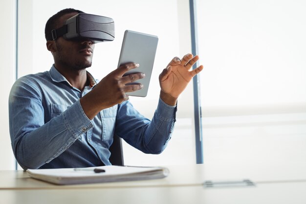 Uomo d'affari utilizzando le cuffie da realtà virtuale e la tavoletta digitale