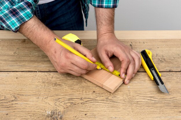 Uomo del carpentiere utilizzando righello e matita