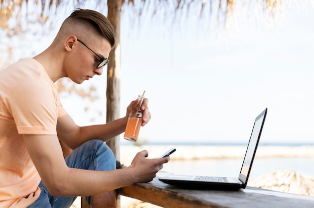 Uomo del colpo medio all'aperto con il computer portatile