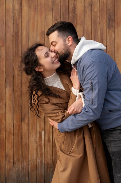 Uomo del colpo medio che bacia la donna sulla guancia