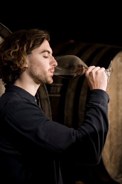 Uomo del colpo medio che beve vino vecchio