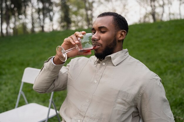 Uomo del colpo medio che beve vino