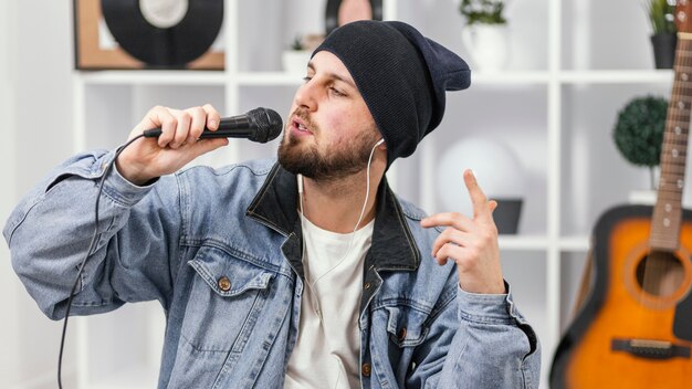 Uomo del colpo medio che canta al microfono