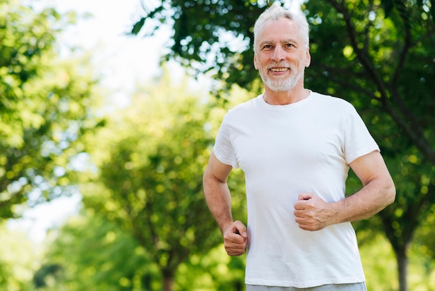 Uomo del colpo medio che corre all'aperto