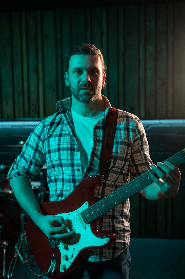 Foto gratuito uomo del colpo medio che gioca la chitarra