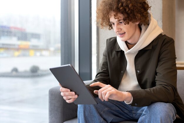 Uomo del colpo medio che legge rivista digitale