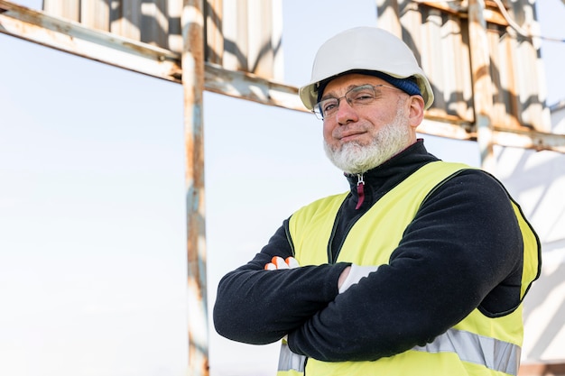 Uomo del colpo medio che posa con il casco