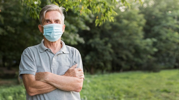 Uomo del colpo medio che posa nella natura