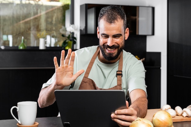 Uomo del colpo medio che saluta al tablet