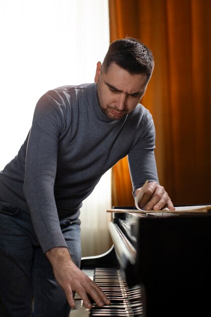 Uomo del colpo medio che suona il pianoforte