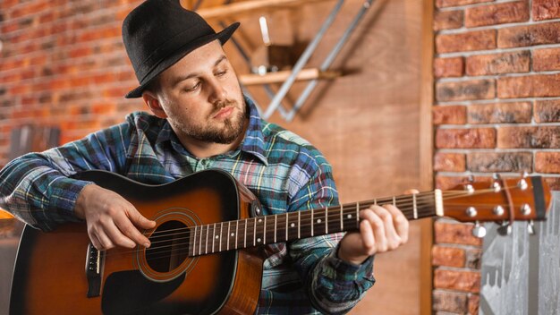 Uomo del colpo medio che suona uno strumento